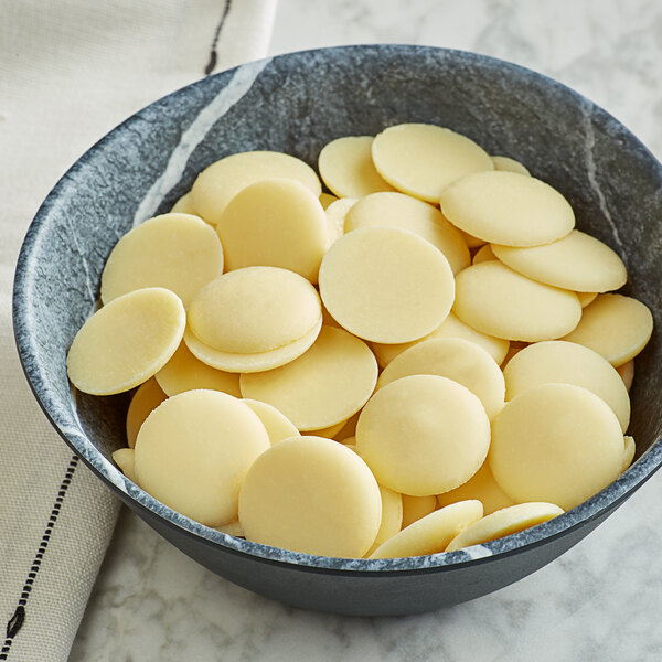 A bowl of Guittard Soie Blanche white chocolate wafers.