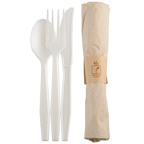 A white plastic fork, spoon, and knife with a white napkin and utensils set.