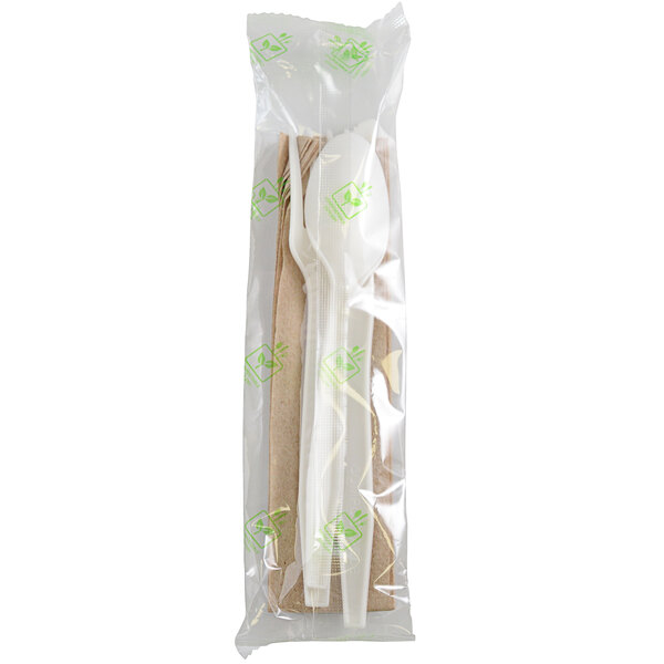 A white plastic bag containing individually wrapped white Fineline CPLA flatware and a napkin.