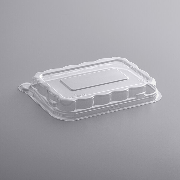 A white plastic Fineline PETE dome lid on a clear plastic container.