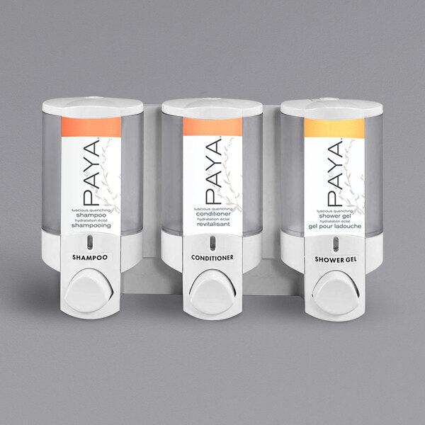 A white wall-mounted Dispenser Amenities Aviva soap dispenser with three translucent bottles.