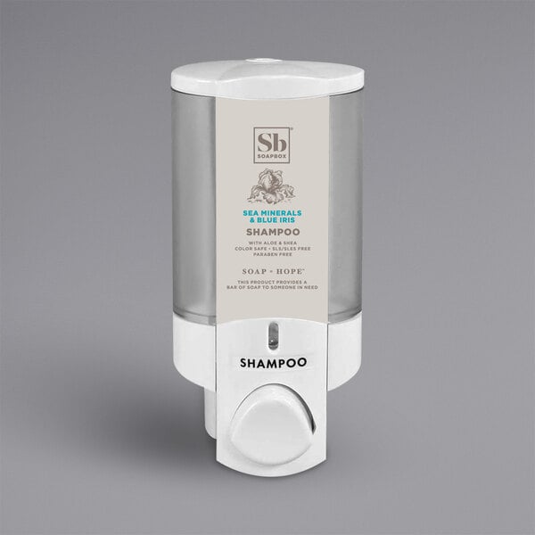 A white Dispenser Amenities Aviva wall mounted soap dispenser with a translucent bottle and Soapbox logo.