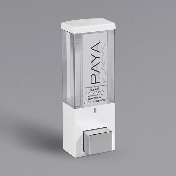 A white Dispenser Amenities wall-mounted shower dispenser with a clear plastic bottle and Paya logo.