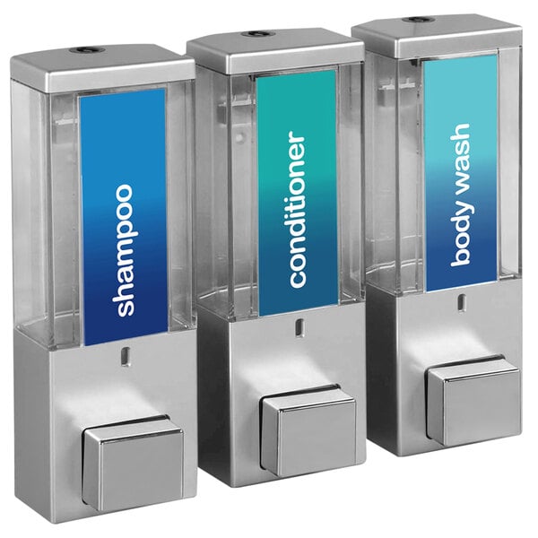 A silver wall-mounted 3-chamber shower dispenser with translucent bottles labeled for soap.