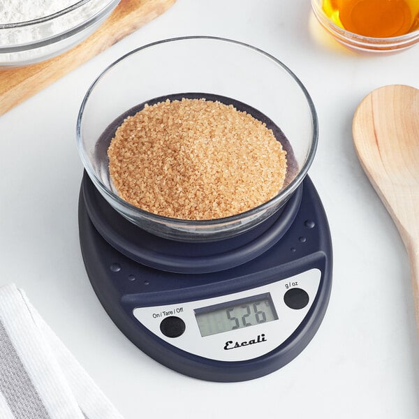 A blue San Jamar digital portion scale with a bowl of brown sugar on a white counter.