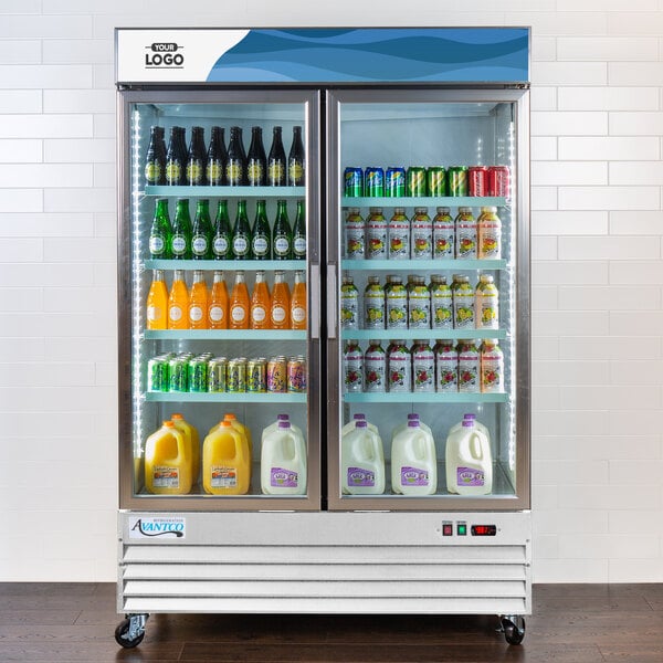 An Avantco white swing glass door refrigerator filled with drinks on shelves.