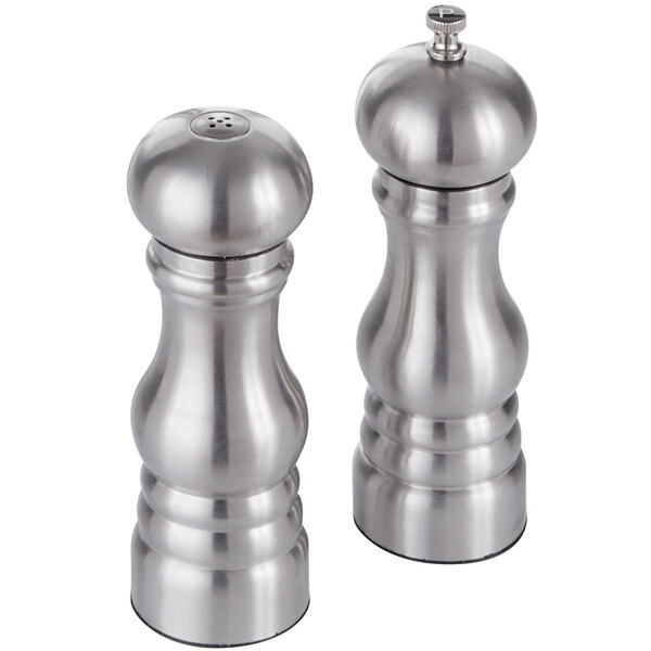 An American Metalcraft stainless steel salt shaker with a black lid next to a silver stainless steel salt shaker with a hole in the lid.