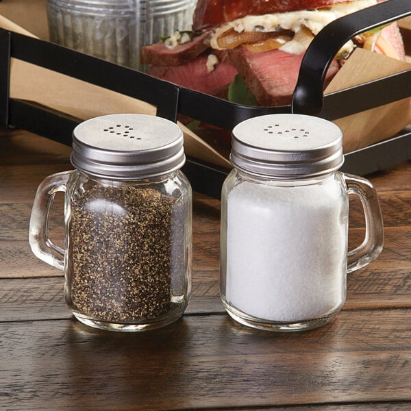 An American Metalcraft mason jar salt and pepper shaker set on a table.