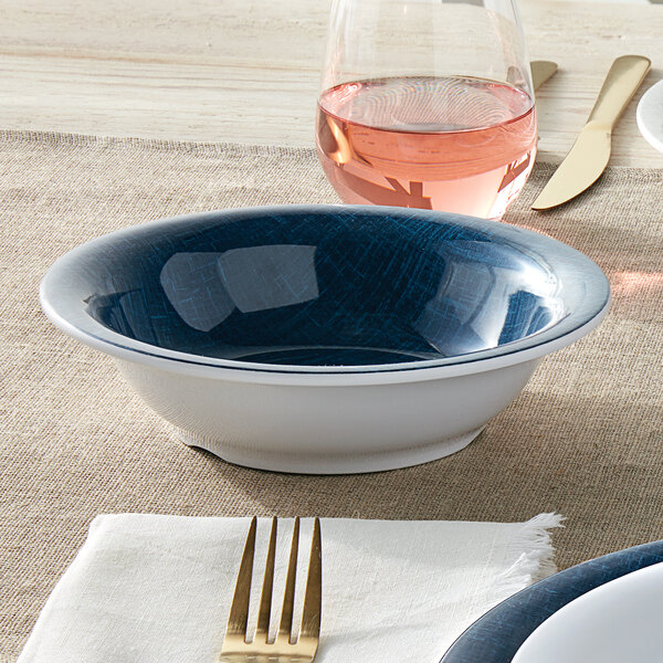 An American Metalcraft Jane Casual denim melamine bowl on a table with a fork and knife.