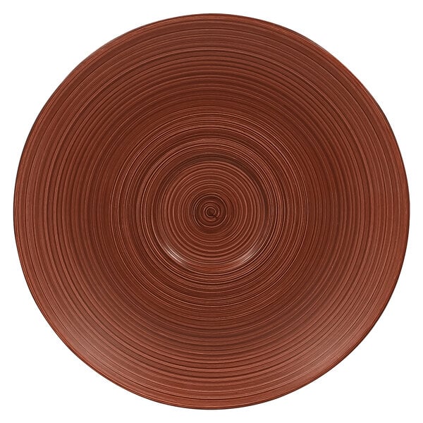 A brown circular RAK Porcelain saucer with spirals on it.