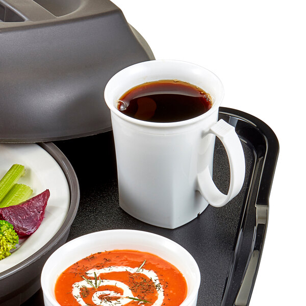 A table set with a tray of soup and two white Cambro insulated mugs filled with brown liquid.
