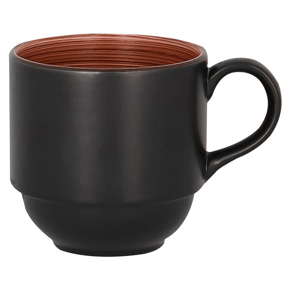 A white background close up of a stackable RAK Porcelain Trinidad walnut and black cup with brown liquid and a brown rim.