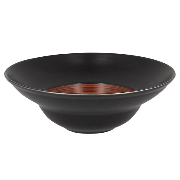 A white porcelain plate with a black bowl and brown rim.