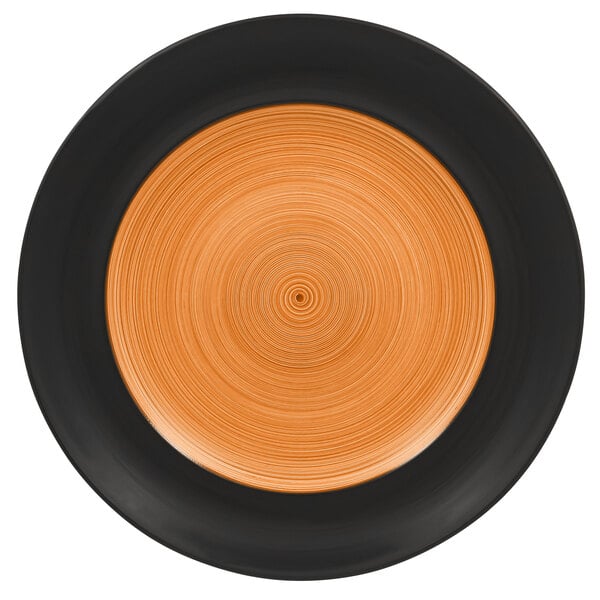 A close up of a RAK Porcelain Trinidad wide rim porcelain plate with a black and orange circular design.