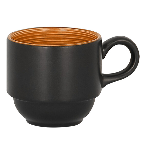 A close up of a black and brown stackable porcelain cup with a cedar orange interior.