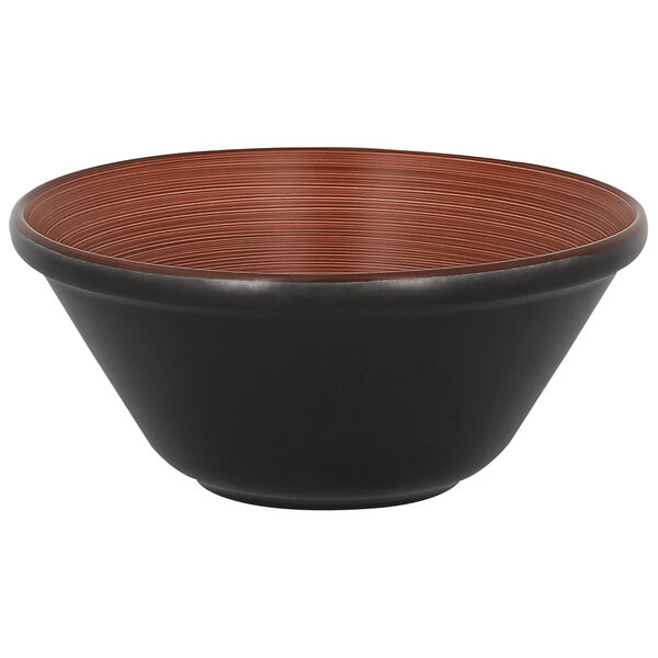 A black porcelain bowl with a brown rim from RAK Porcelain on a table.