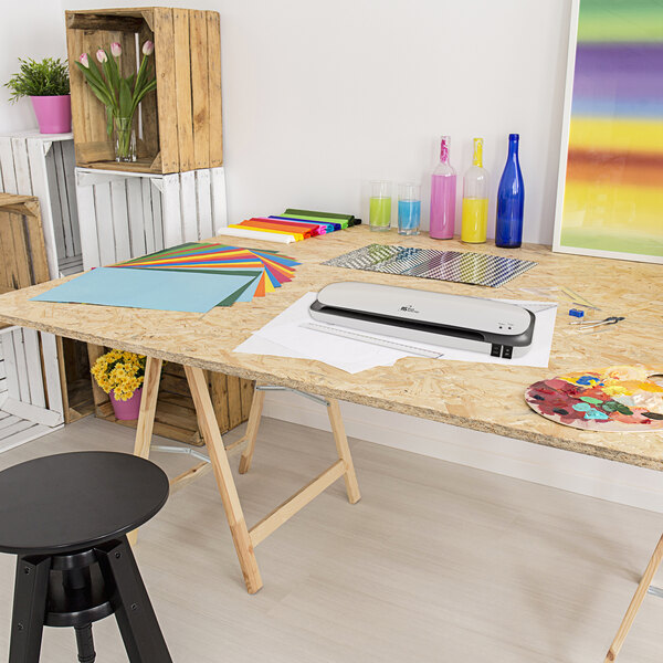 A Royal Sovereign laminator on a desk with a printer and paper.
