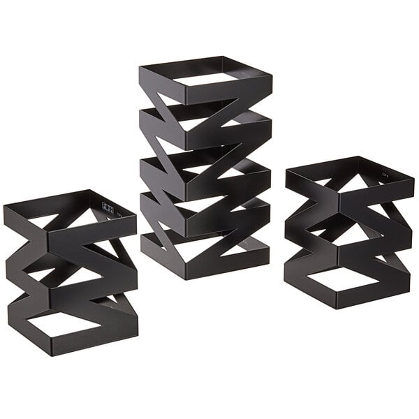 A group of three matte black stainless steel rectangular risers with zigzag designs.