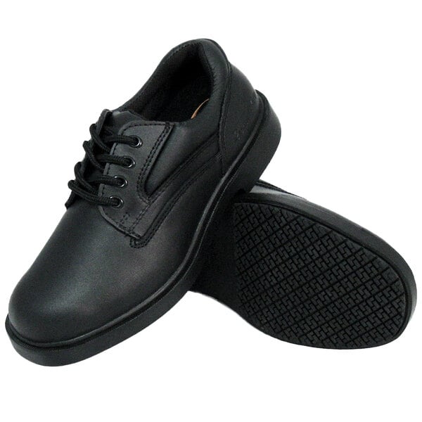 A pair of black leather Genuine Grip women's oxford shoes with black rubber soles.