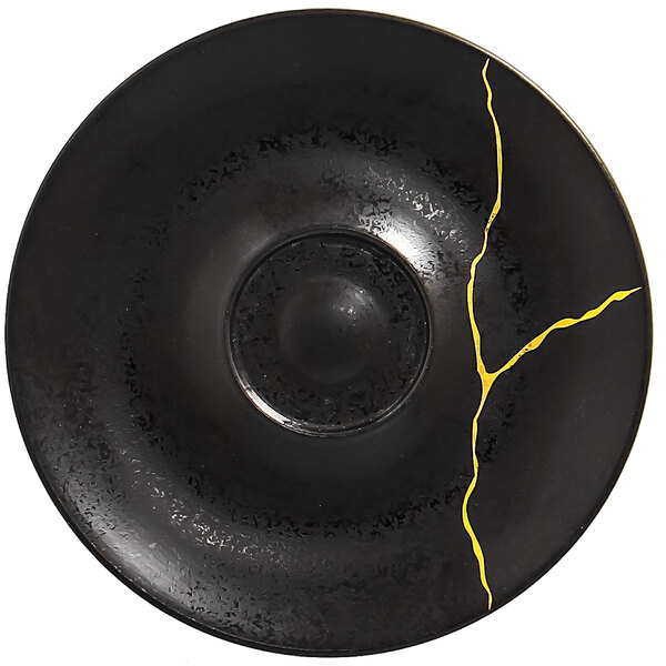 A black RAK Porcelain saucer with a gold crackle design on it.