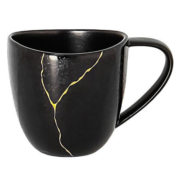A black porcelain espresso cup with gold lines on it.