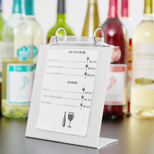 An Alumitique aluminum menu tent with top rings on a table with a wine menu.