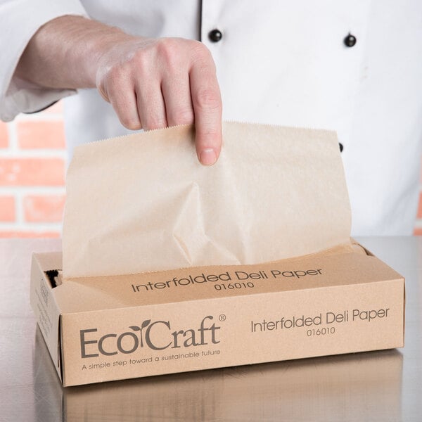 A person opening a brown Bagcraft Packaging EcoCraft deli paper bag.