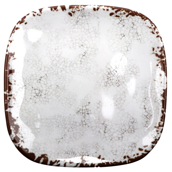A white square melamine plate with brown speckles.