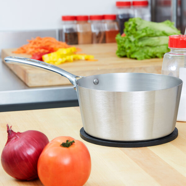A Vollrath stainless steel sauce pan on a counter.