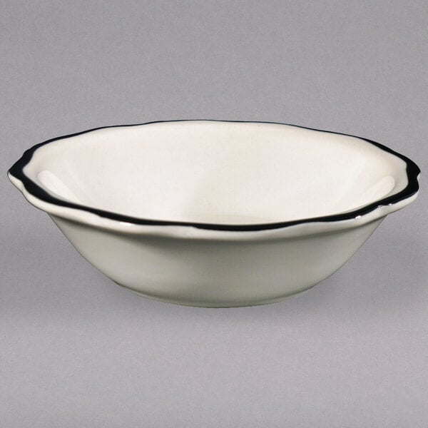A CAC Seville Ivory fruit bowl with a black rim.