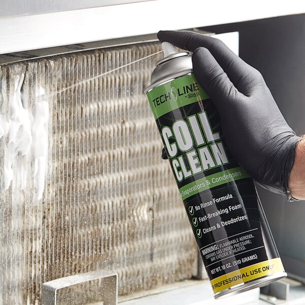 A person wearing gloves holding a can of Noble Chemical Tech Line foaming evaporator and condenser coil cleaner spray.