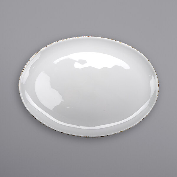 A white oval melamine platter with brown speckles on the rim.