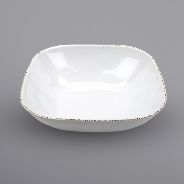 A white square melamine bowl with gold speckles.