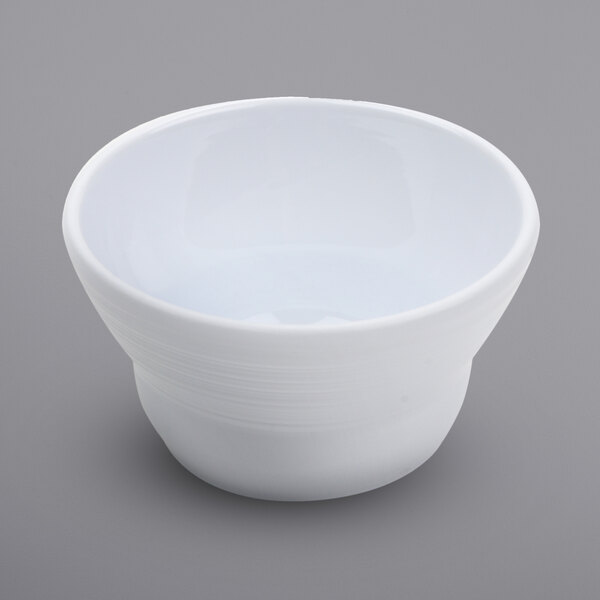 A white Minski melamine fruit bowl on a gray surface