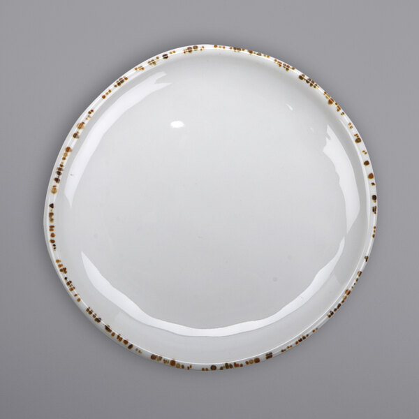 A white plate with brown speckled spots.