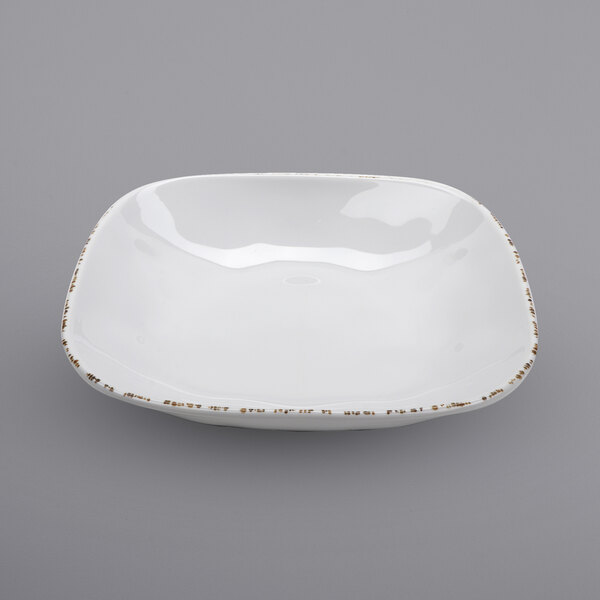 A white square melamine bowl with irregular edges and a white surface.