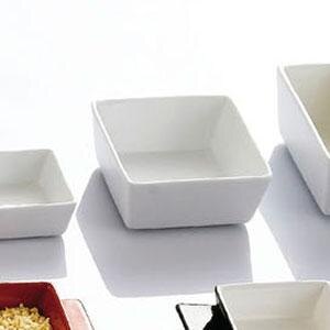 A variety of CAC white square China tasting bowls on a white surface.