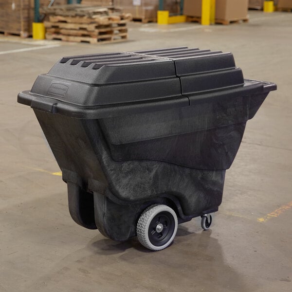 A black Rubbermaid tilt truck trash cart on wheels.