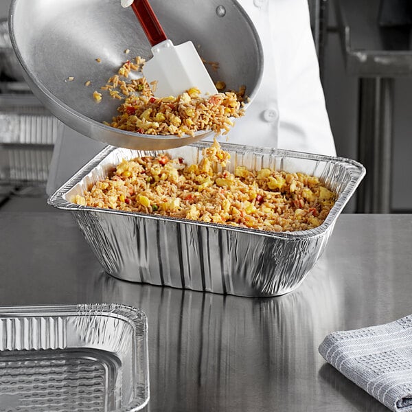 A Choice half-size extra-deep foil steam table pan with food in it.