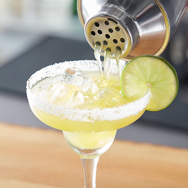 A glass of Island Oasis margarita with a lime wedge.
