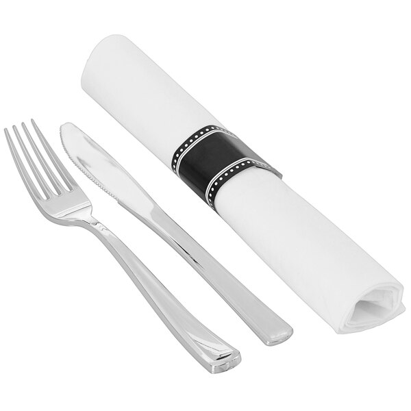 A Fineline white napkin rolled with a silver heavy weight plastic fork and knife.