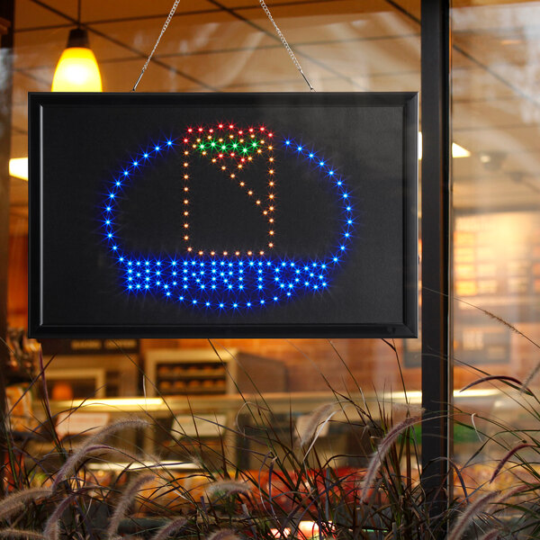 A white rectangular LED sign that says "Burritos" with lights on it.