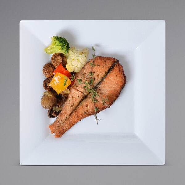 A Fineline Settings white square plastic dinner plate with a piece of salmon and vegetables.