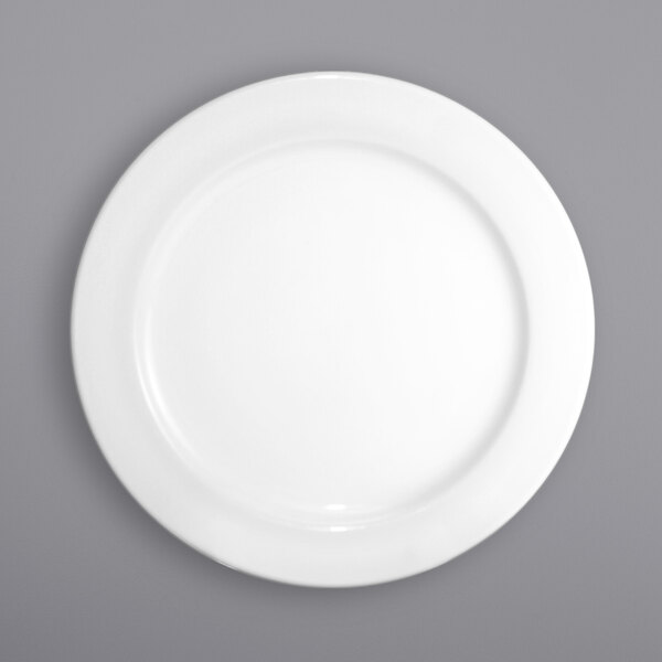 An International Tableware Dover porcelain plate with a wide rim on a gray background.
