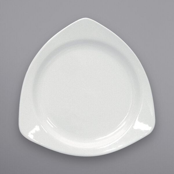 A close-up of a International Tableware European White triangular porcelain plate.