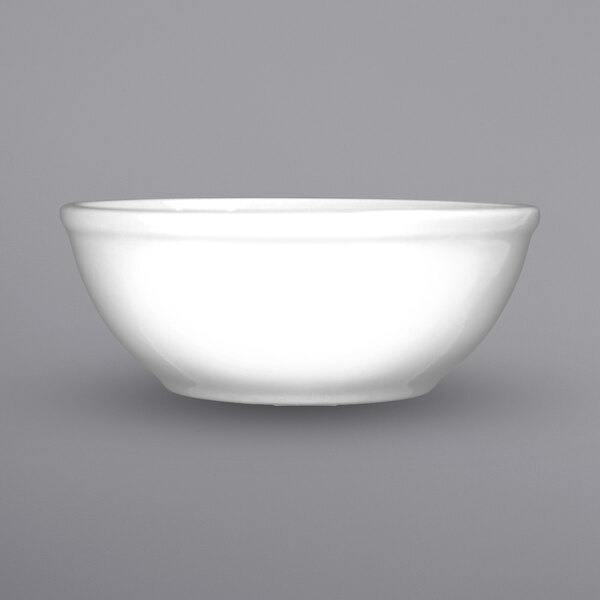 A close-up of an International Tableware Dover white porcelain nappie bowl.