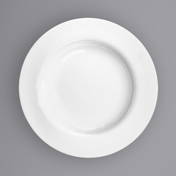 A close-up of a International Tableware Bristol wide rim porcelain plate with a white background.