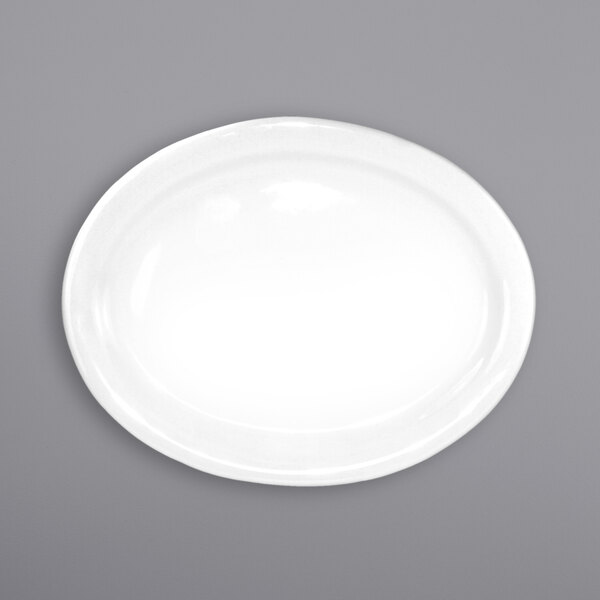 An International Tableware oval porcelain platter with a white rim on a gray surface.