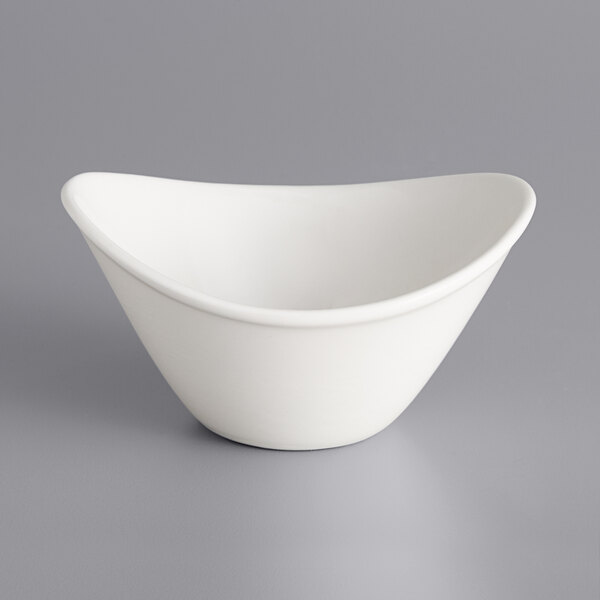 An International Tableware Dover white porcelain bowl with a curved rim on a gray surface.