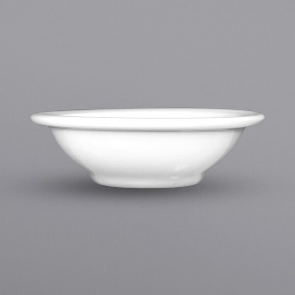 A close up of a white International Tableware Bristol porcelain fruit bowl with a rim.